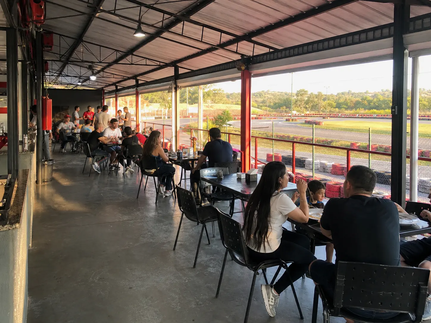 Área coberta de convivência com mesas de frente para a pista
