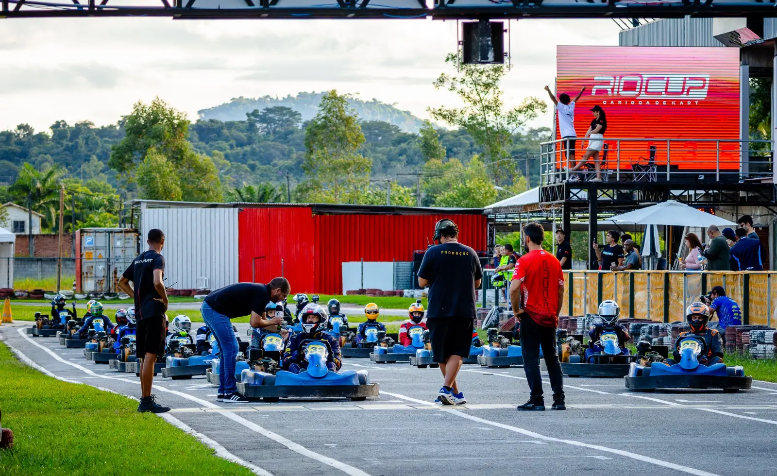 Pilotos e equipe preparando o grid de karts antes da largada