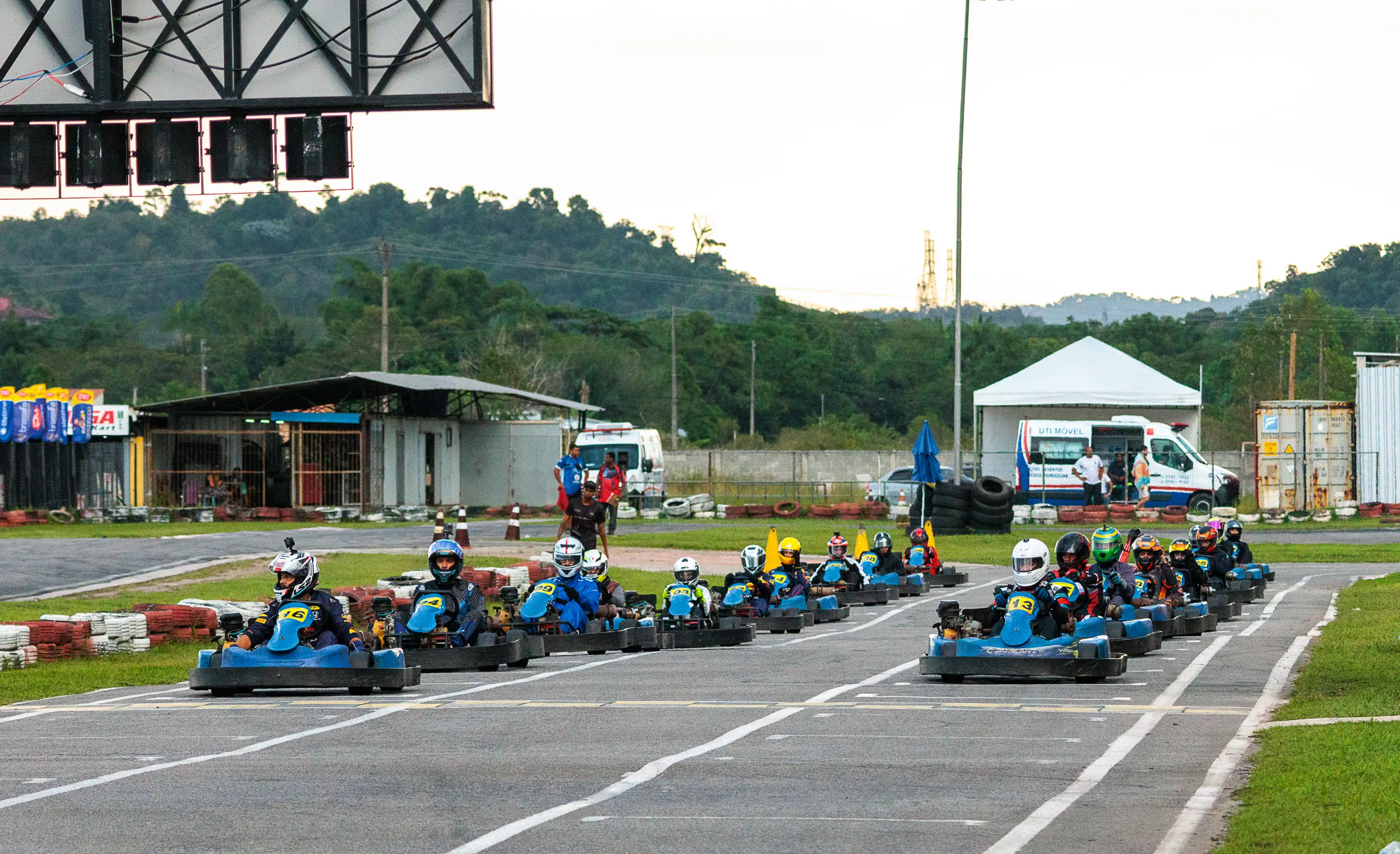 Público acompanhando um pelotão de karts de aluguel junto à pista outdoor
