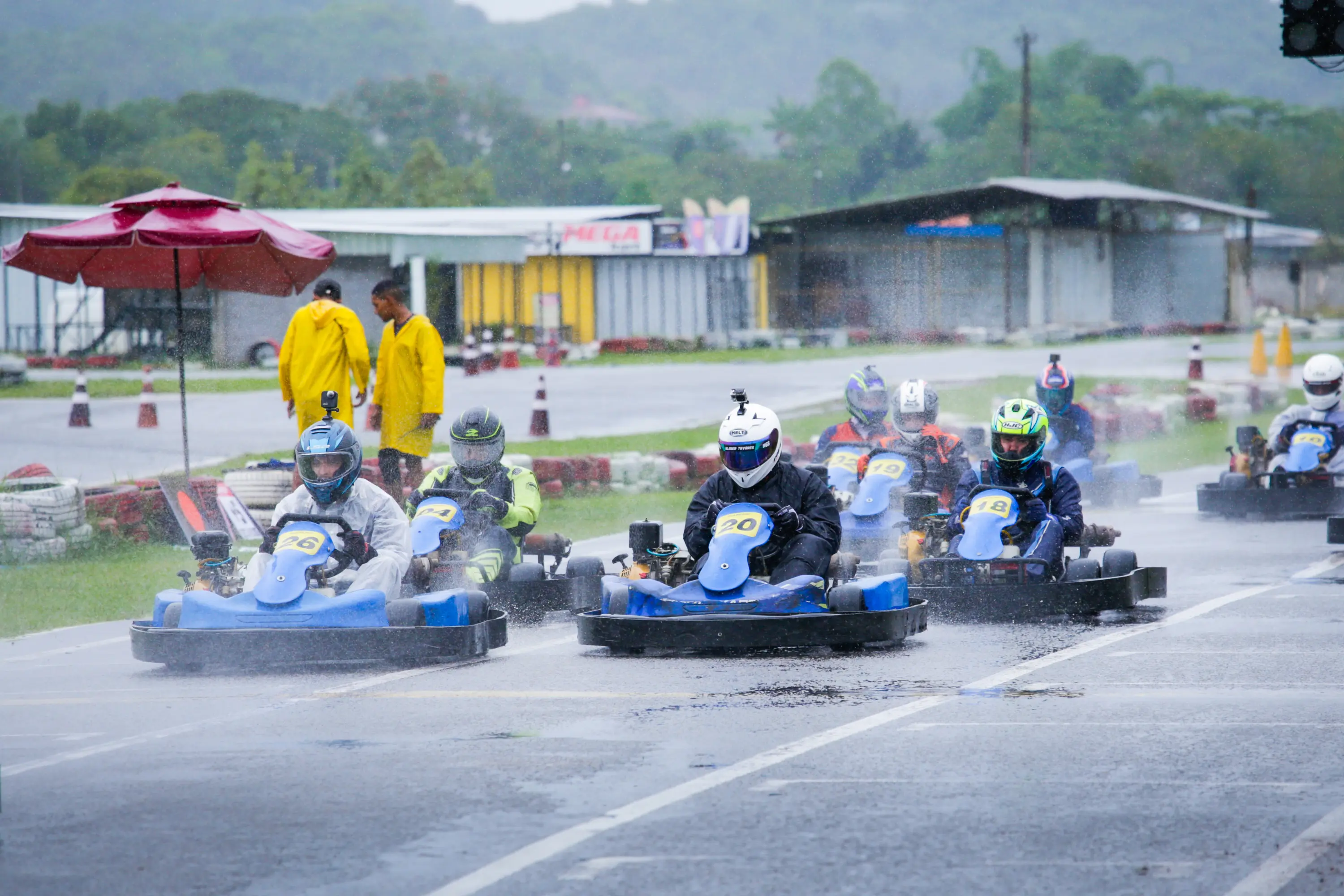Pelotão disputando posição sob chuva na pista outdoor do KIG