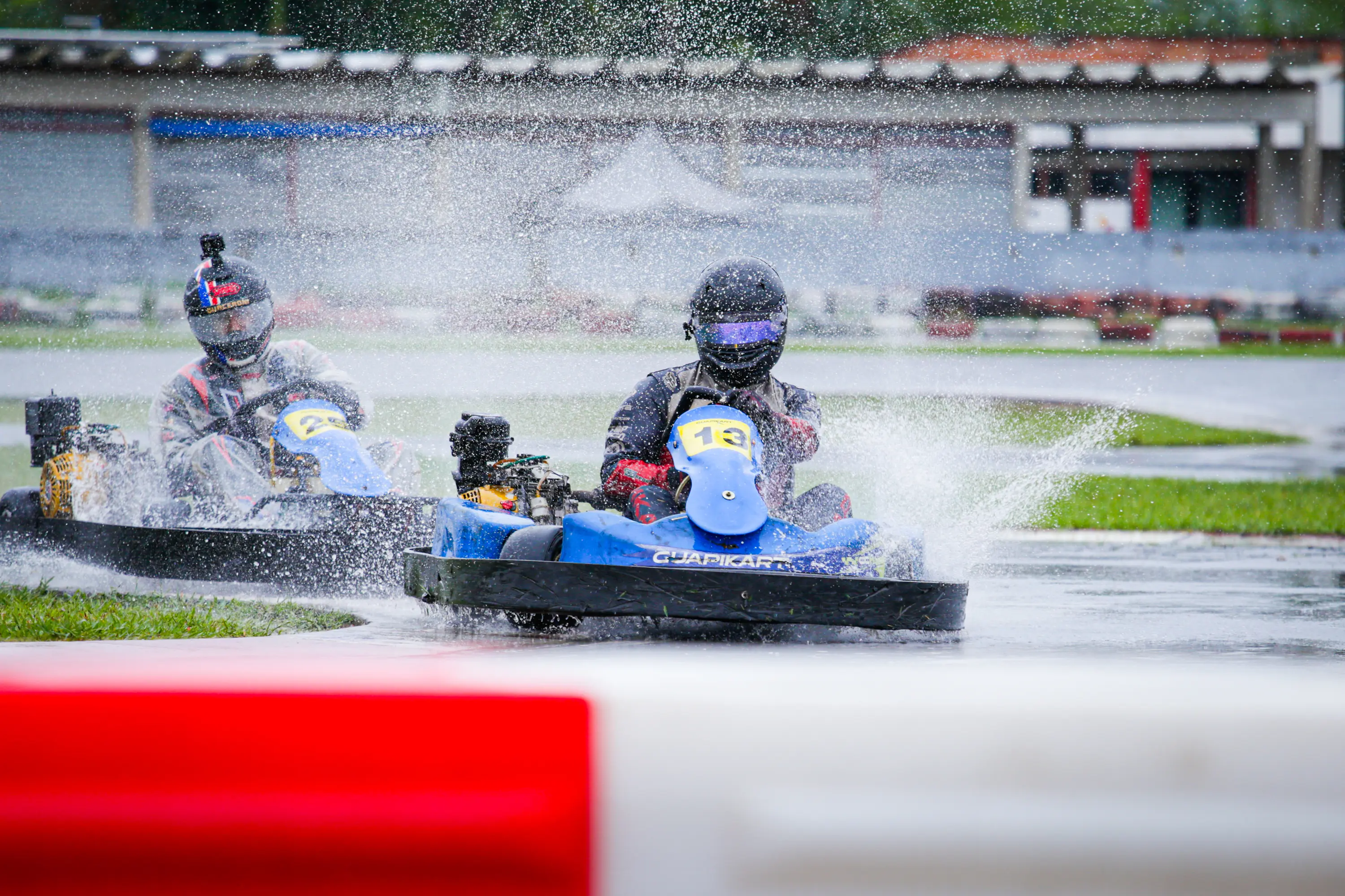 Pelotão de karts de aluguel disputando posição na chuva